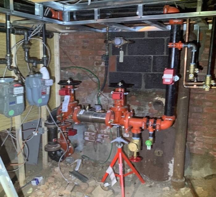 Commercial plumbing installation with red and black piping