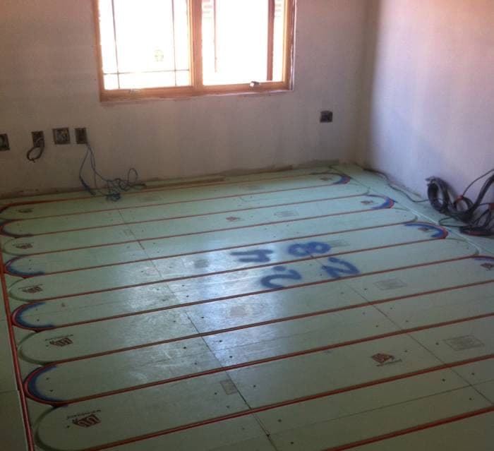 Radiant floor heating panels being installed in a room